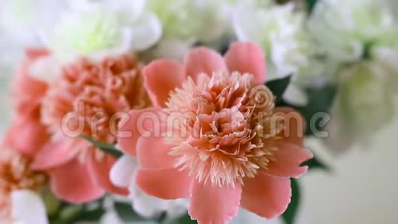 室内简易玻璃罐内的新鲜大珊瑚粉红色白色和奶油牡丹花束美丽的花瓶视频的预览图