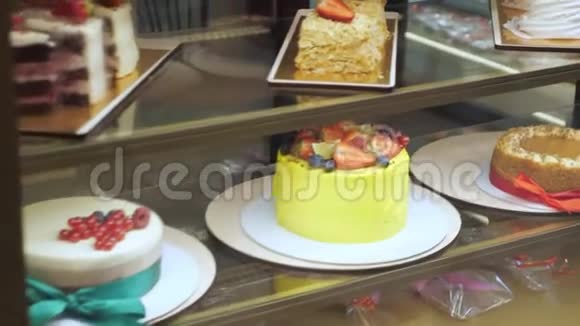 黄色蛋糕新鲜浆果和奶油在面包店橱窗玻璃架子上视频的预览图