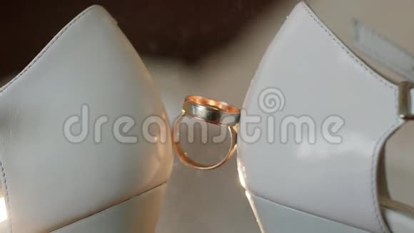 喷雾香水订婚戒指放置在新娘的婚礼鞋之间快关门宏观慢动作视频的预览图