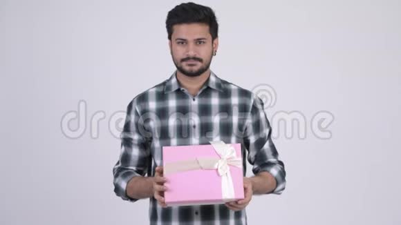 年轻快乐留胡子的印度男人送礼盒的肖像视频的预览图