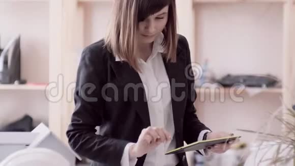 穿着西装的白种人女孩看着平板电脑检查桌子上的铅笔图视频的预览图