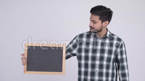 年轻有压力的留着胡子的印度男人拿着黑板竖起大拇指视频的预览图