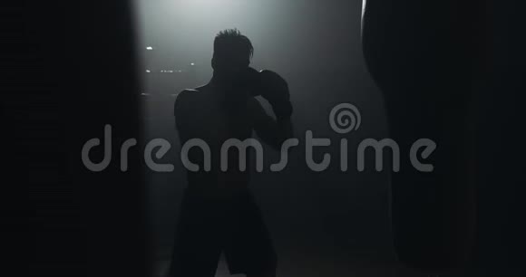 剪影拳击手在黑暗的健身房打拳关闭战斗机训练男拳击手在黑暗中锻炼跆拳道视频的预览图