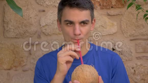 年轻可爱的男人喝椰子水视频的预览图