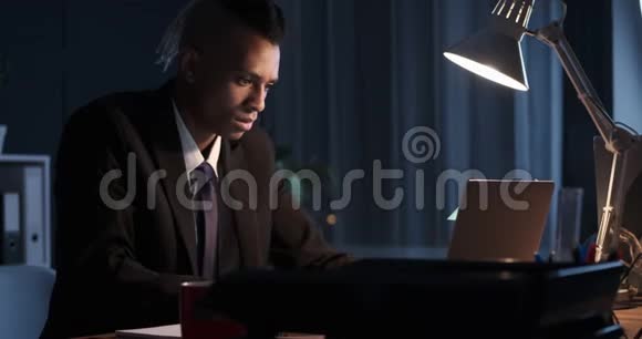 商务人员使用笔记本电脑并在夜间办公室做笔记视频的预览图