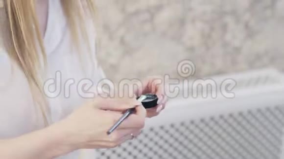 一个化妆师用一个小刷子的特写取一个银色颜料用刷子把多余的东西抖掉然后应用视频的预览图