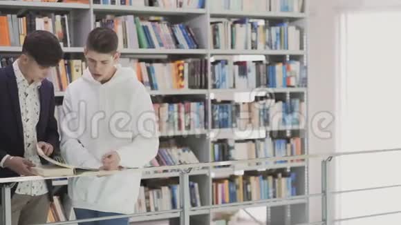两个年轻学生在图书馆看书和准备考试视频的预览图