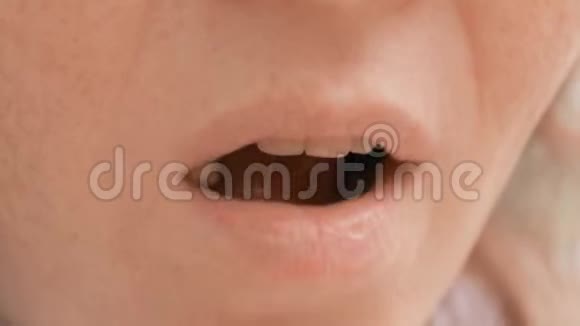 女人的嘴闭上在公园外面吃食物手指把甜爆米花送到嘴里视频的预览图
