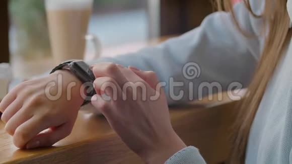 女士使用智能手表触摸屏可穿戴技术设备特写镜头在智能手表上做手势的漂亮女孩视频的预览图