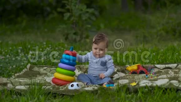美丽的小男孩在花园里独自玩耍视频的预览图