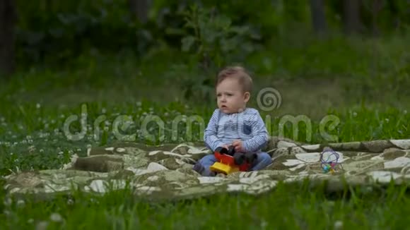 美丽的小男孩在花园里独自玩耍视频的预览图