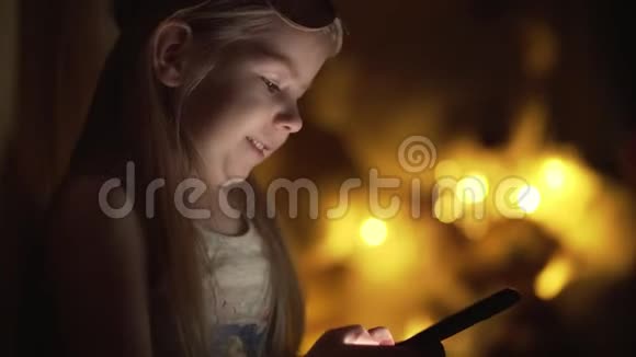 小女孩打字留言夜间使用智能手机与共用空间视频的预览图