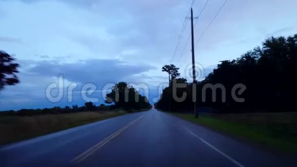 在白天驾驶农村潮湿的道路俯瞰多云的天空雨水暗雨后的POV驾驶点视频的预览图