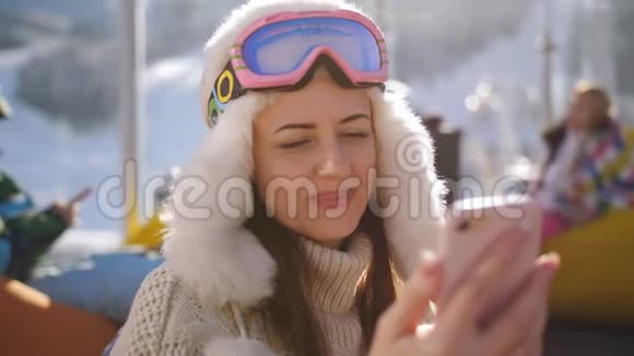快乐的女人在滑雪场的咖啡馆里休息和朋友在信使上交谈视频的预览图