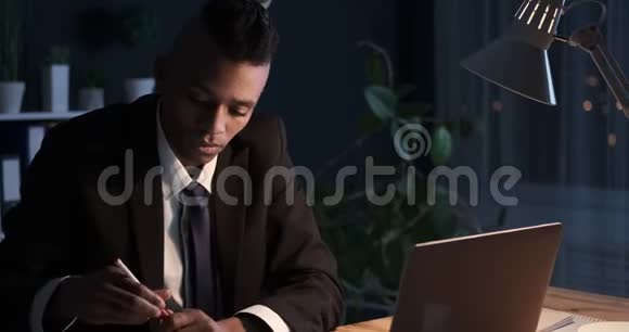 商务人员使用笔记本电脑并在夜间办公室做笔记视频的预览图