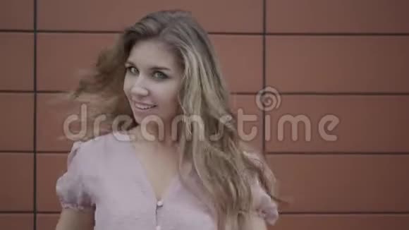 一个穿着粉红色裙子的蓝眼睛年轻女人的特写肖像视频的预览图