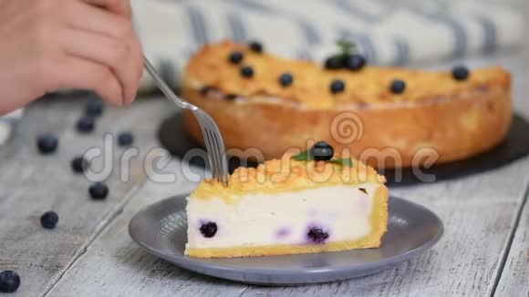盘子里放着蓝莓芝士蛋糕女人吃蓝莓芝士蛋糕视频的预览图