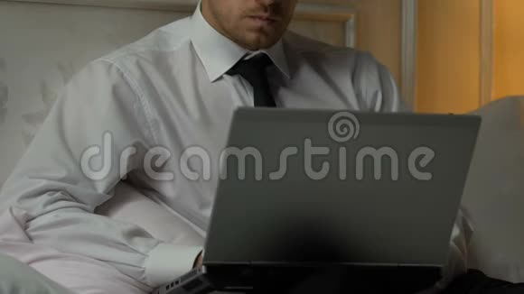 一个人在笔记本电脑上打周报一个忙碌的记者在床上写文章视频的预览图