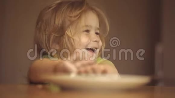 快乐的孩子吃早餐可爱的孩子在家吃早餐厨房里的孩子在桌子旁吃饭宝贝视频的预览图