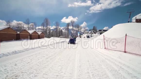 朋友们在滑雪场玩得很开心微笑的年轻人骑着雪地摩托三个人在雪地摩托上享受视频的预览图