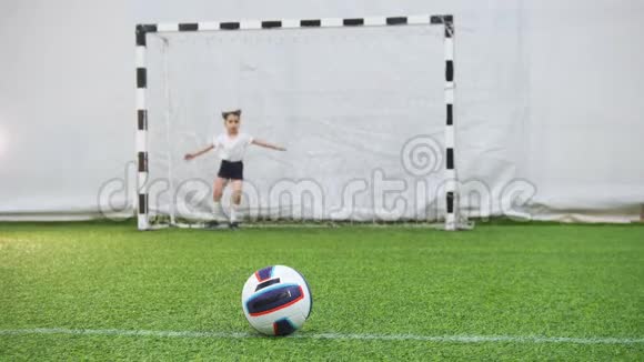 孩子们在室内足球场踢足球一个小孩踢球但是看门人保护大门视频的预览图