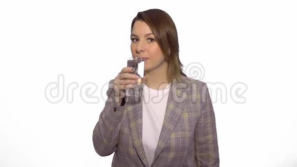 年轻开朗的白人妇女喝着干净的水在白色背景下竖起大拇指视频的预览图