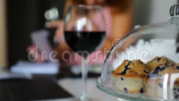 一杯红酒旁边透明盖子下的纸杯蛋糕视频的预览图