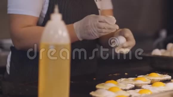 女人把鸡蛋打碎倒在一个金属热盘子里视频的预览图