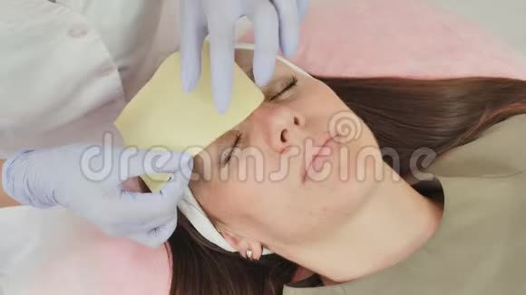一个美容师女人在眉毛纹身后擦眉眉毛的永久纹身视频的预览图