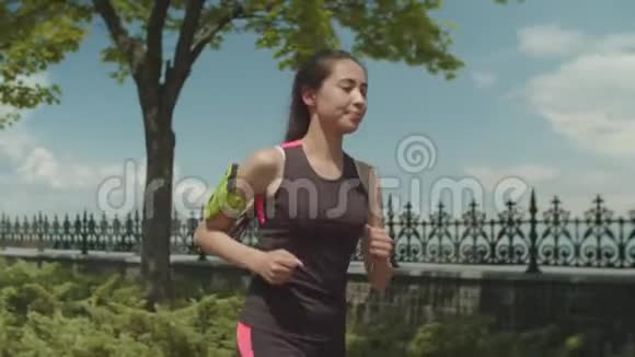 运动期间在城市公园慢跑的女运动员视频的预览图