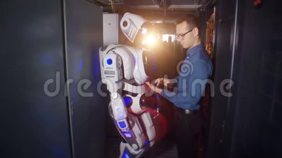 工程师在机器人的显示器上打字一个程序员和一个机器人站在服务器机房里准备工作视频的预览图