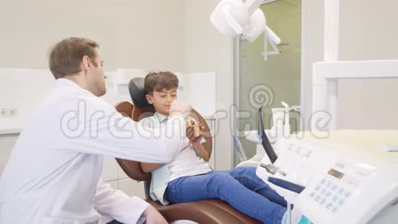 男性牙医教育小男孩牙科卫生视频的预览图
