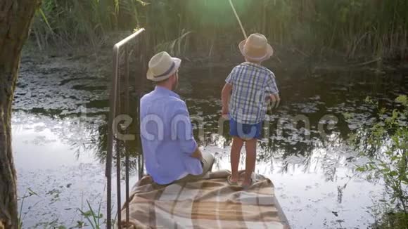 钓鱼的家庭父亲和他的小儿子一起享受时光因为他在假期钓到了他的第一条鱼视频的预览图