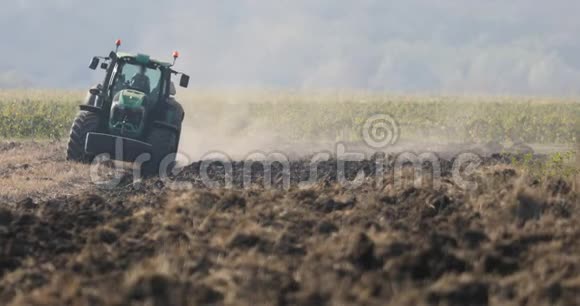 绿色拖拉机在田里犁旱地视频的预览图