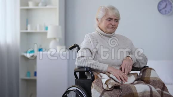 坐在轮椅上的老年妇女感到头痛问护士要止痛药视频的预览图
