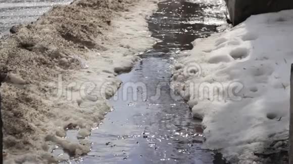 水从融化的雪沿沥青流动视频的预览图