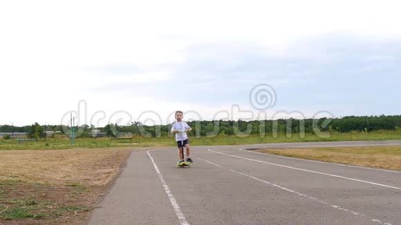 快乐的孩子骑着滑板车在赛道上慢动作视频的预览图
