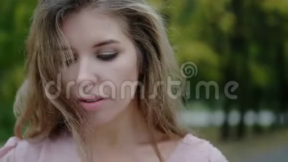 一个穿着粉红色裙子的蓝眼睛年轻女人的特写肖像视频的预览图