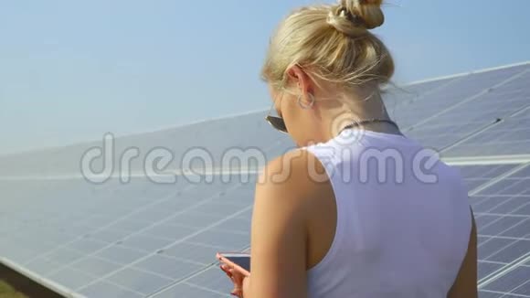 年轻女孩在太阳能电池板附近打电话视频的预览图