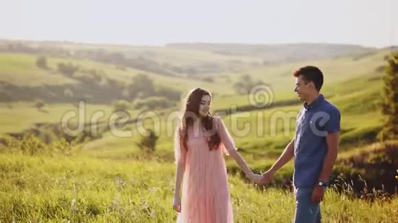日落时分浪漫的情侣在公园里牵手快乐的一对情侣视频的预览图