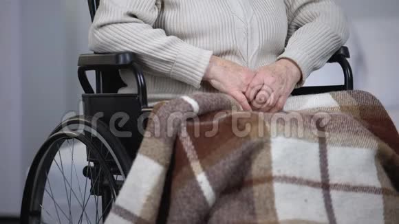 坐在轮椅上的老太太擦着脸上的泪水看着镜头孤独视频的预览图
