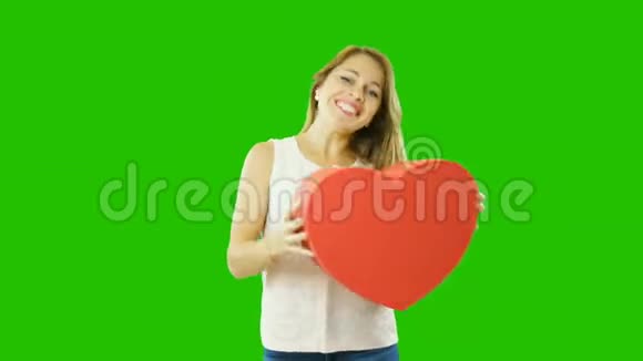 一个迷人的女孩在一个单独的屏幕上放着情人节的心形礼物视频的预览图