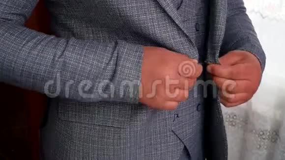 男士双手扣紧夹克穿西装的时髦男人在夹克上扣扣子视频的预览图