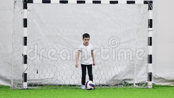 室内足球场一个看门的小男孩踢着球开始比赛视频的预览图