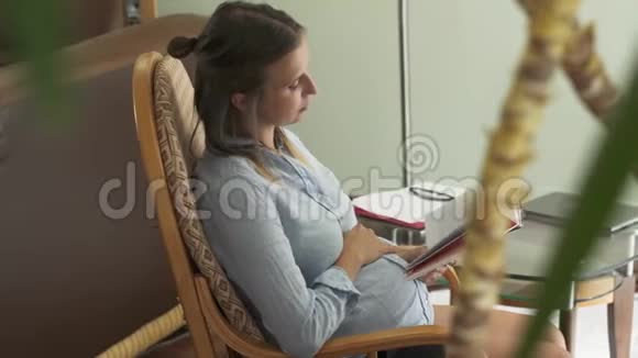 坐在椅子上看书的孕妇视频的预览图