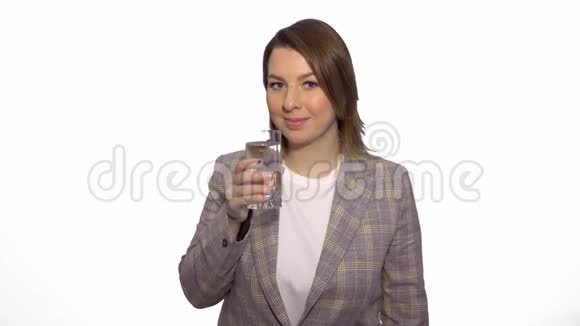 年轻开朗的白人妇女喝着干净的水在白色背景下竖起大拇指视频的预览图