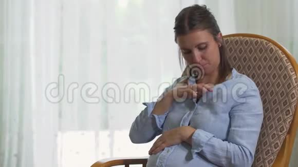坐在椅子上的孕妇测量体温视频的预览图