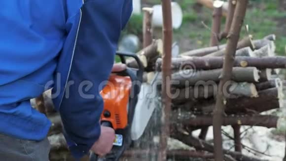 不知名的伐木工人在森林里用电锯锯树视频的预览图