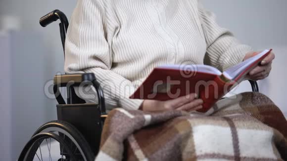 坐在轮椅上看照片的沮丧女人思念家人孤独视频的预览图
