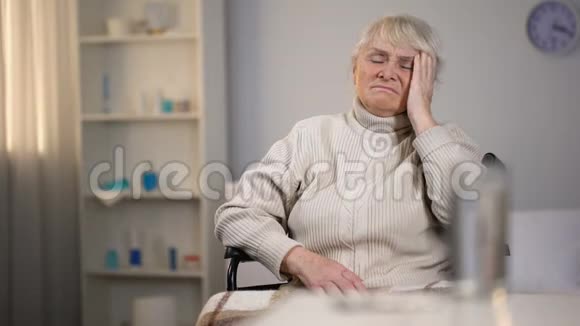 沮丧的老太太头痛看着药丸医疗中心视频的预览图
